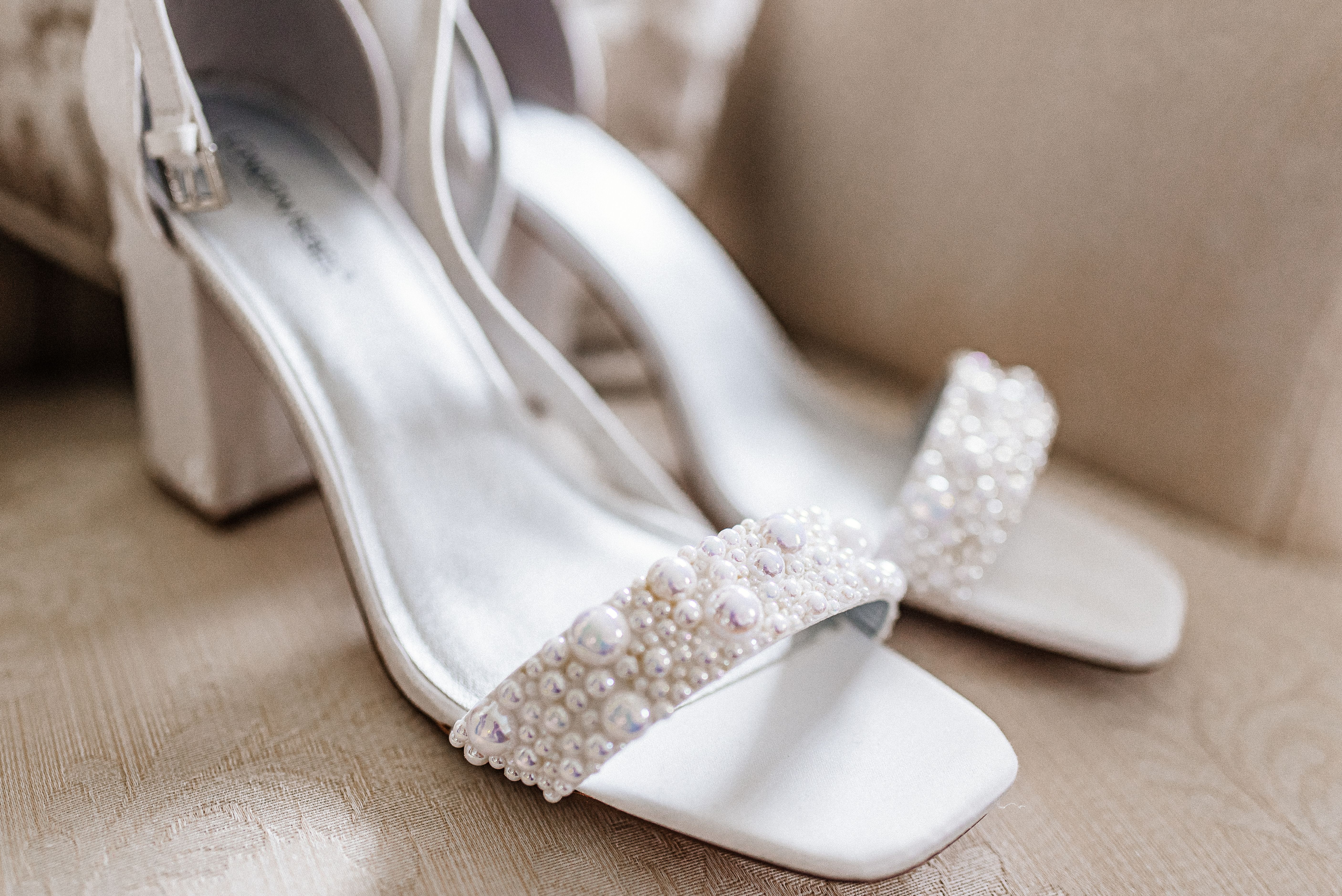 Bridal shoes arranged beside wedding details