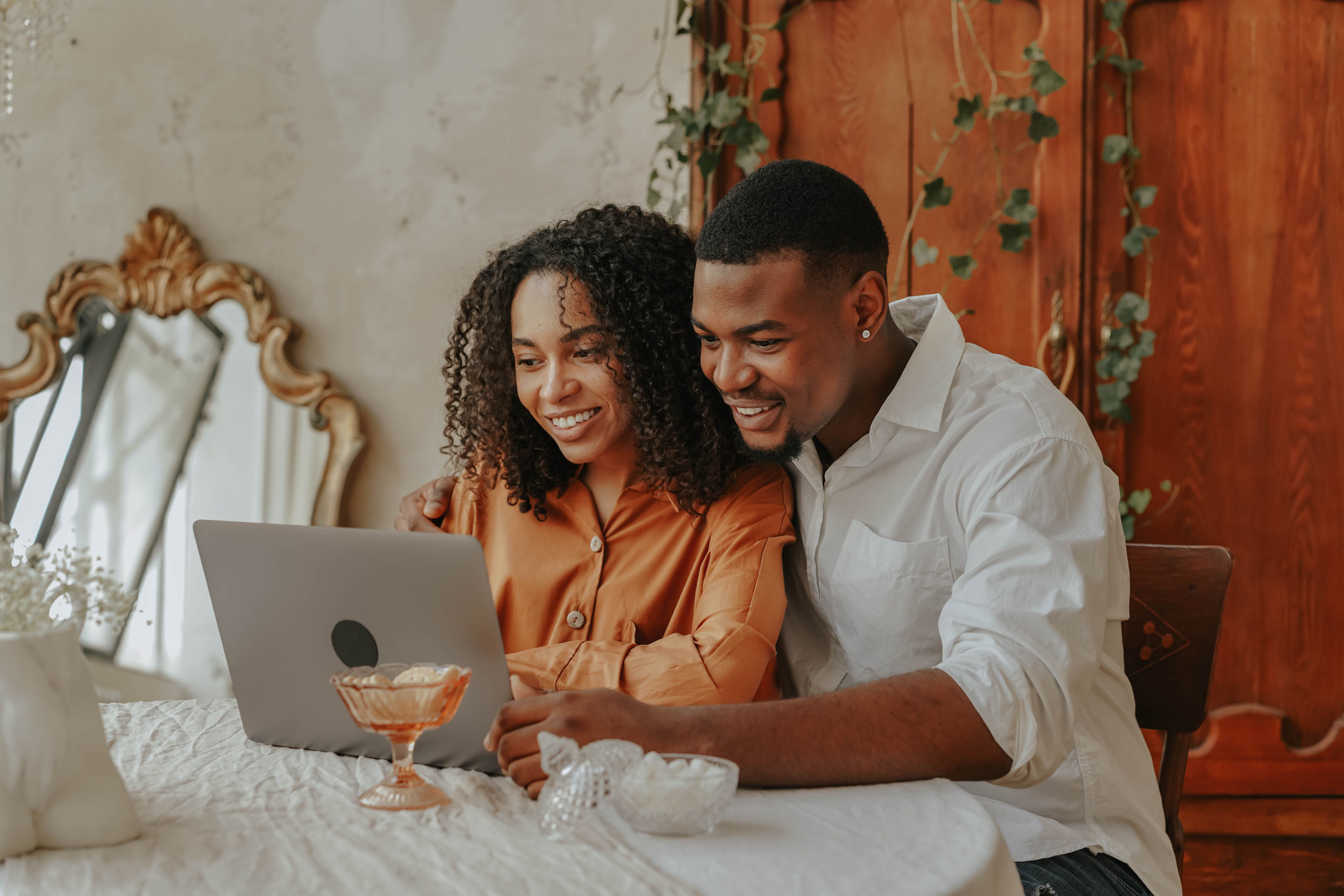 Engaged couple planning their wedding together on a laptop