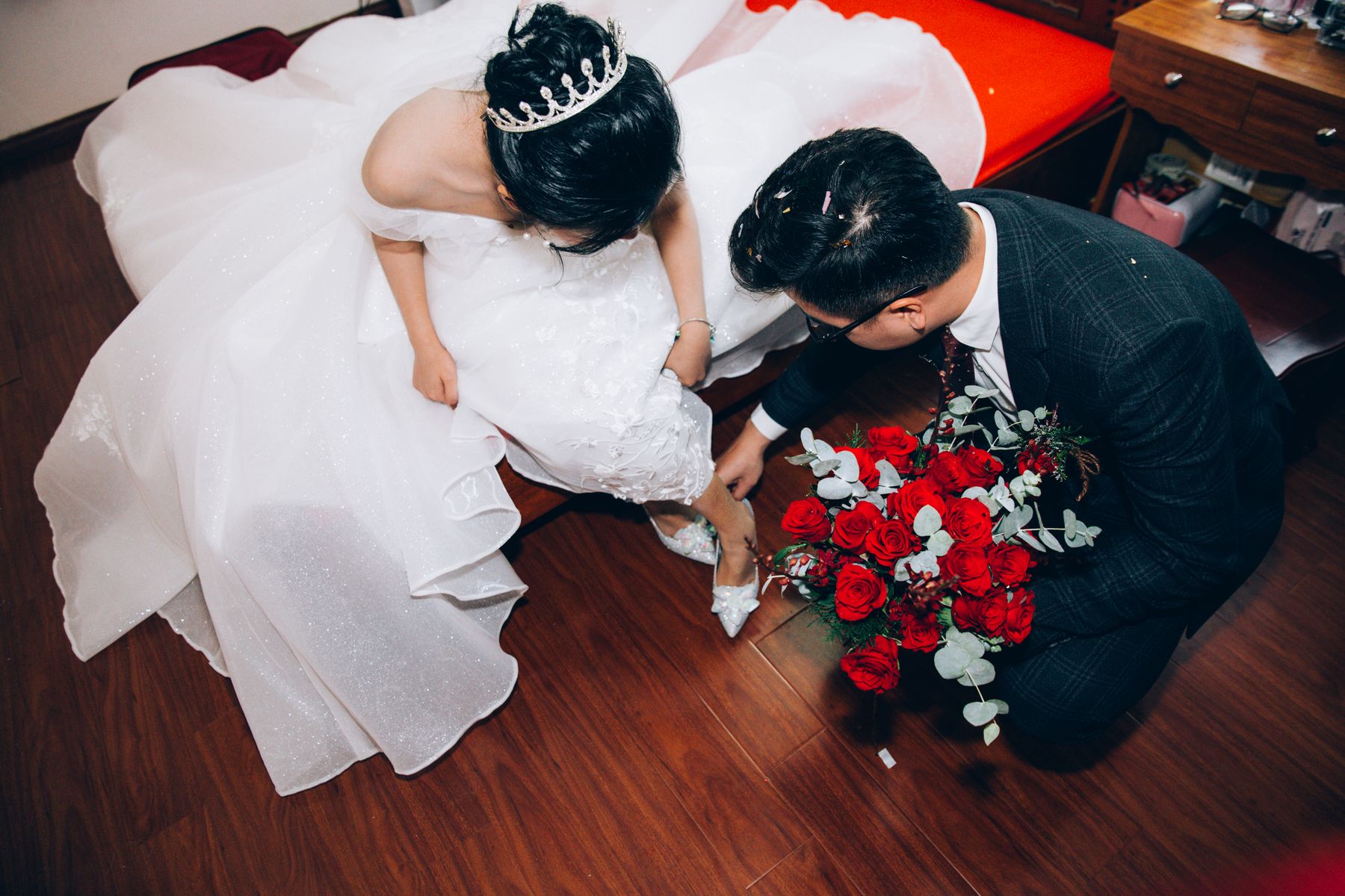 Bride and groom helping each other prepare for their wedding