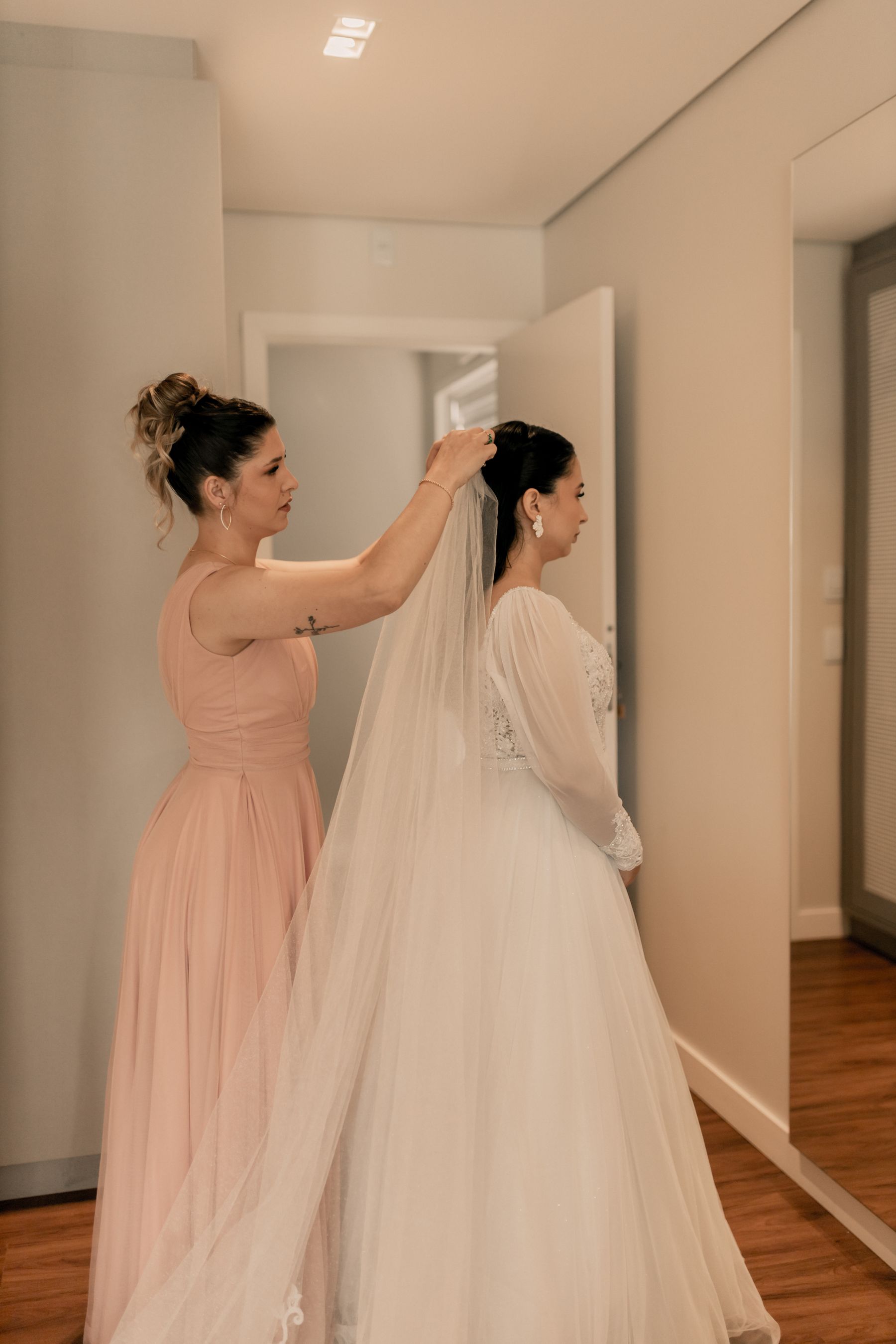 Bridesmaid helping a bride arrange her veil before the ceremony