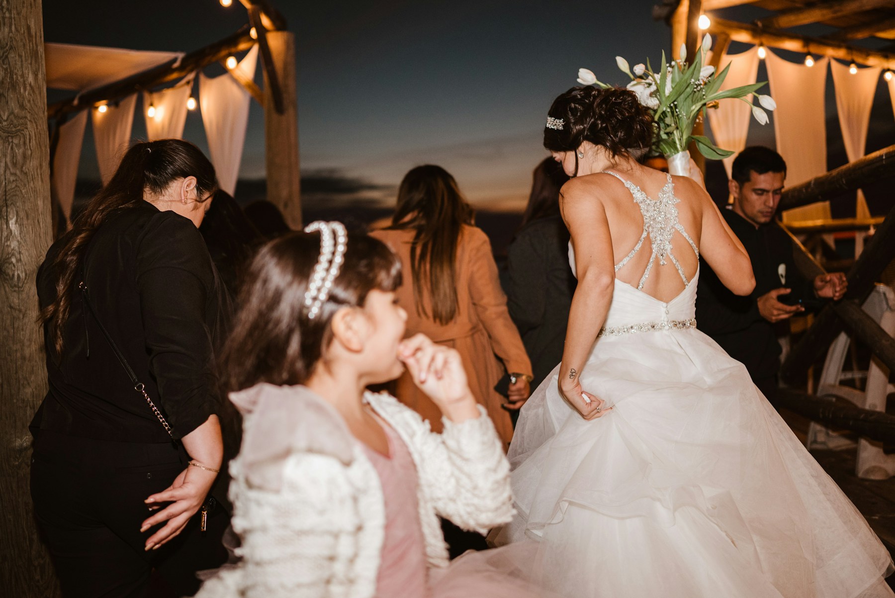 Bride dancing with guests at an outdoor wedding reception