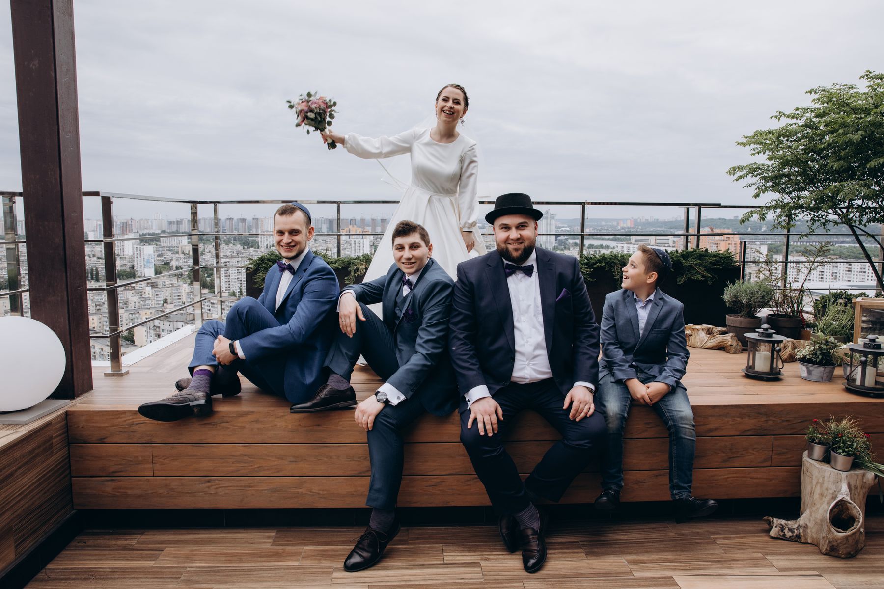 Newlyweds celebrating outdoors with their wedding party