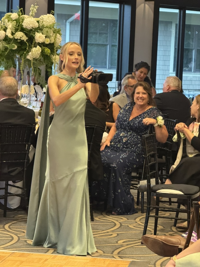 Wedding guest filming candid reception moments with a camcorder