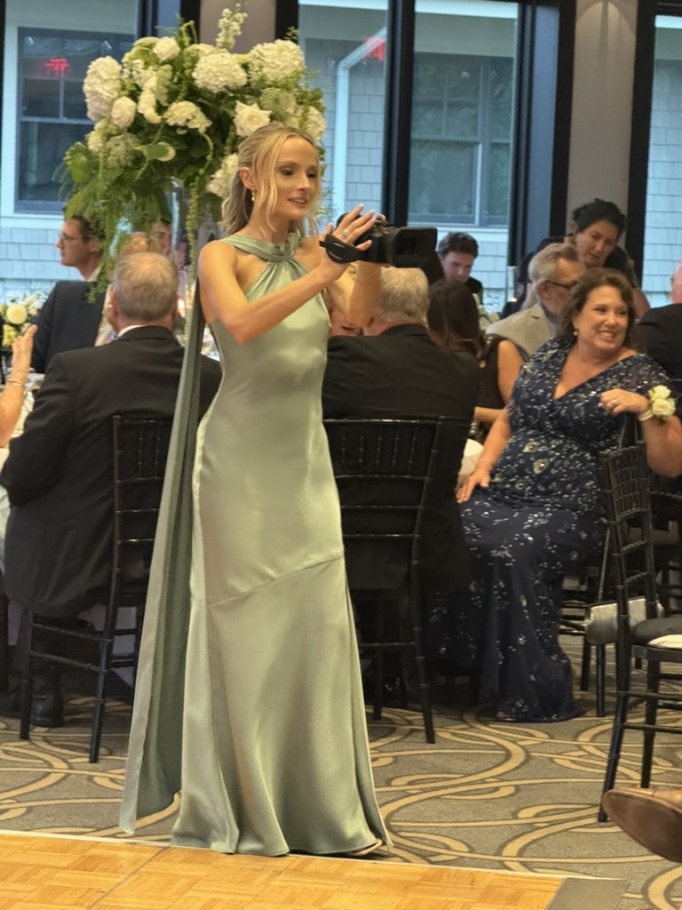 A compact camcorder being used during a wedding celebration